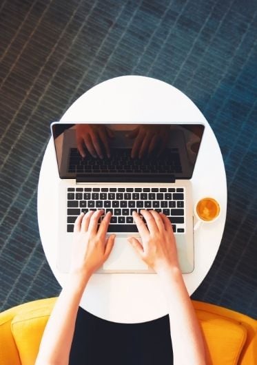 An aerial photo of a person typing on a laptop